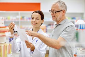pharmacist and senior man buying drug at pharmacy